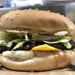 Lot-O-Burger with a toasted sesame seed bun, American cheese, dressed; mayo, mustard, onions (mixed together) pickle, lettuce &amp; tomato.