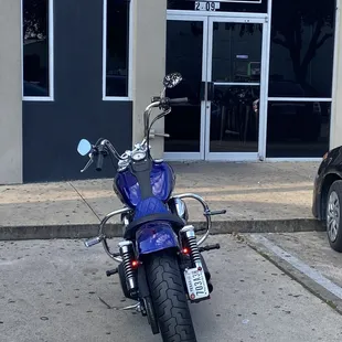 a blue motorcycle parked in front of a building