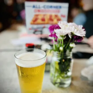 a glass of beer and flowers