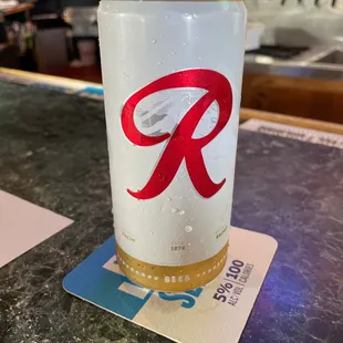 a can of beer on a coaster