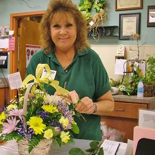 a woman arranging a basket of flowers