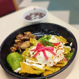 a bowl of nachos and a bowl of guacamole