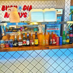 a shelf of drinks and condiments