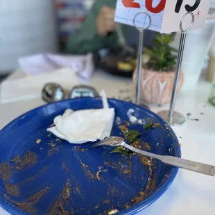a blue plate with a half eaten piece of cake on it