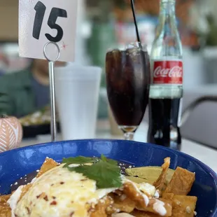 a bowl of nachos and a coke