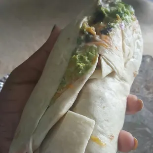 a hand holding a burrito