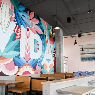 Our main dining area by the bar, featuring a mural by Madrid-based artist collective @BOAMistura