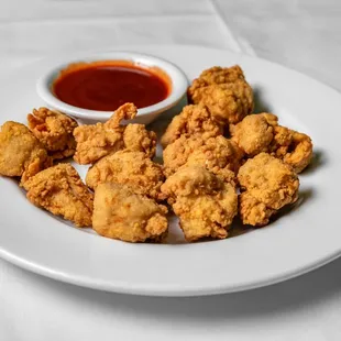 a plate of fried chicken nuggies with dipping sauce