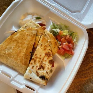 a quesadilla in a styrofoam container