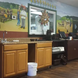 a kitchen with a mural on the wall