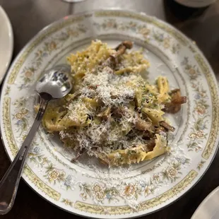 a plate of pasta with mushrooms and parmesan cheese