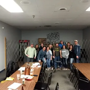 a group of people standing around a conference table