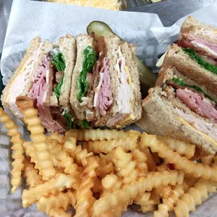 a cut in half sandwich and french fries