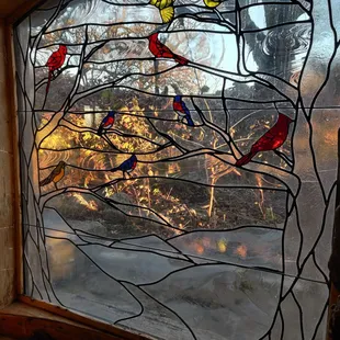 a stained glass window with birds on it