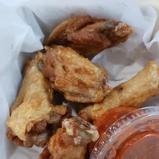 a basket of chicken wings with ketchup