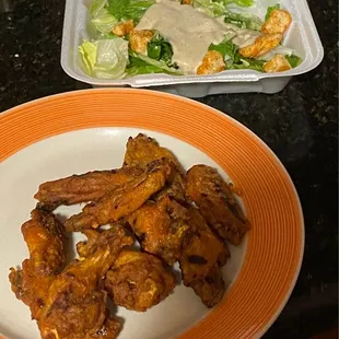 a plate of wings and a salad