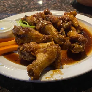 a plate of chicken wings and carrots