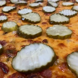 a pizza with pickles on it
