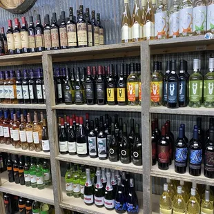 a large selection of wines on shelves