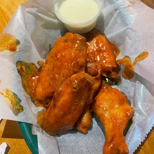 a basket of buffalo wings and a bowl of ranch dressing