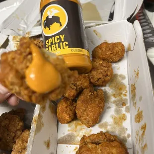 Showing how dry these spicy garlic wings are we received compared to the sauce we put on them ourselves