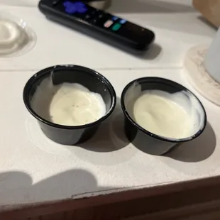 two cups of yogurt and a remote control
