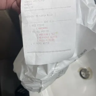 a hand holding a receipt