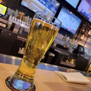 a glass of beer on a bar