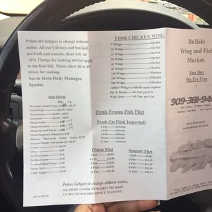 a hand holding a menu