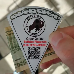 a hand holding a piece of pizza