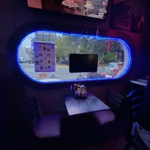 The windows are oval and ringed with blue neon. Kinda dive meets diner vibe.