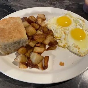 Two eggs Sunny side up with biscuit and potatoes