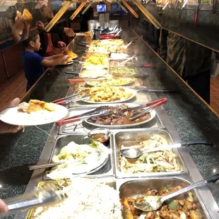 a line of food being served at a buffet