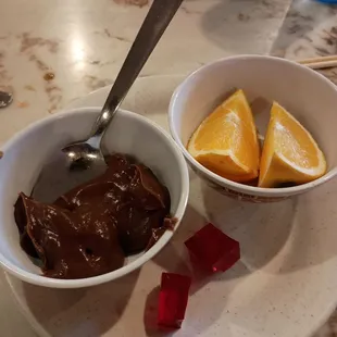 a bowl of chocolate and a bowl of orange slices
