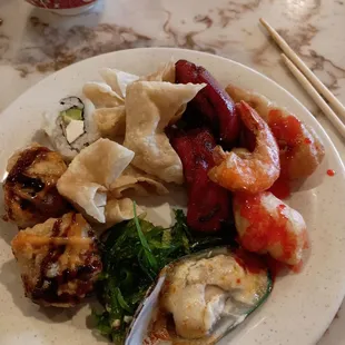 a plate of asian food and chopsticks