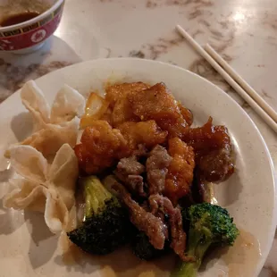a plate of chinese food and chopsticks