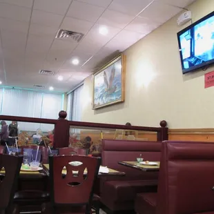 a restaurant with booths and a flat screen tv
