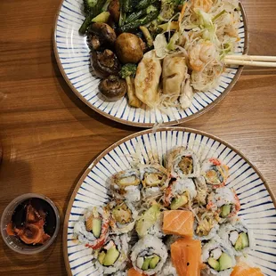 two plates of sushi and vegetables