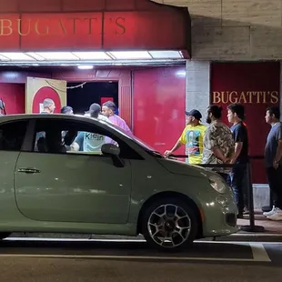  a small car parked in front of a restaurant
