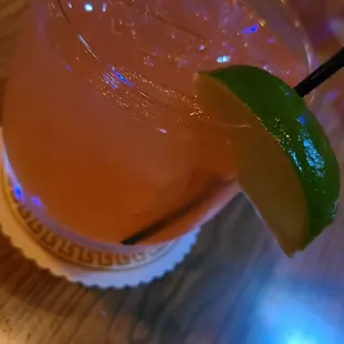 a close up of a drink with a lime wedge