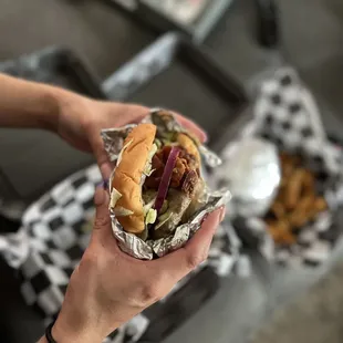 a person holding a hamburger