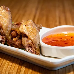 a plate of chicken wings and dipping sauce