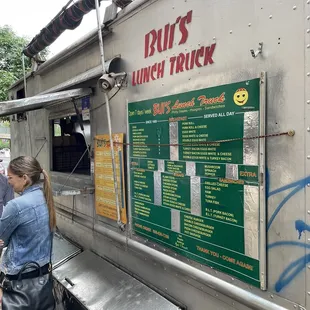a woman standing in front of a food truck
