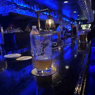 a glass of beer on a bar