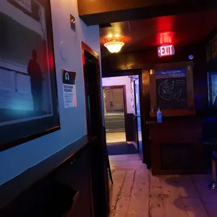 a bar with a television and a bar stool