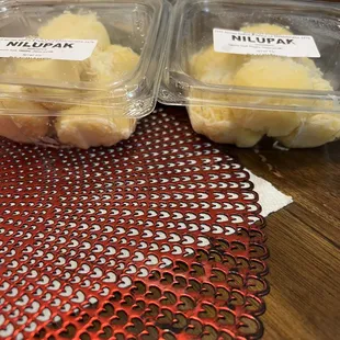 two containers of bananas on a table