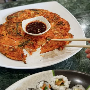 a plate of sushi with chopsticks
