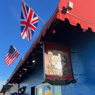 the outside of a bar with a flag flying in the background