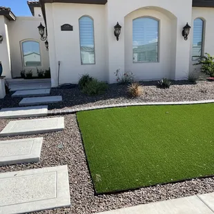 Squared cement steps, Artificial grass installed, and some stone