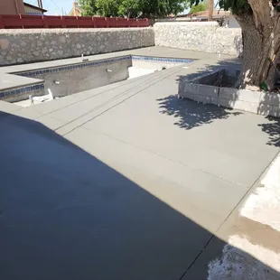 a concrete patio with a pool